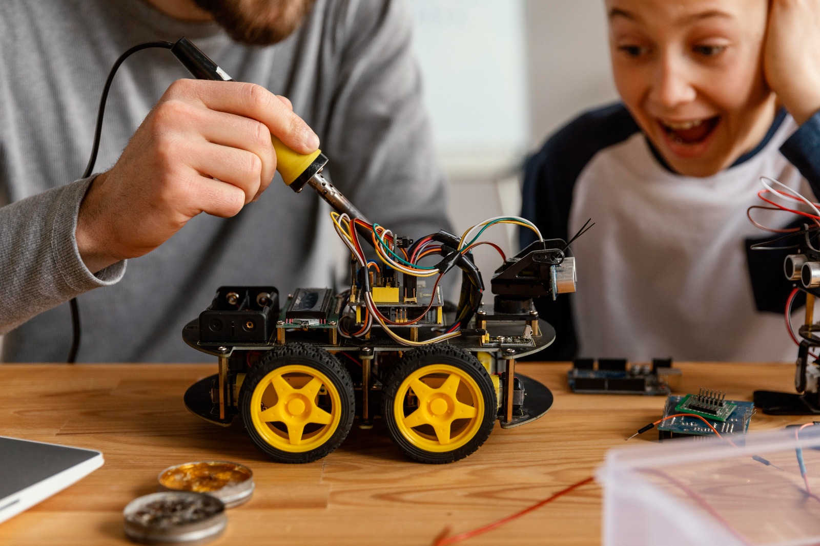 A student and mentor building and wiring a robotics kit