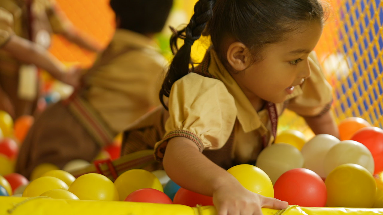 A little girl exploring the ball pit at SKS World School