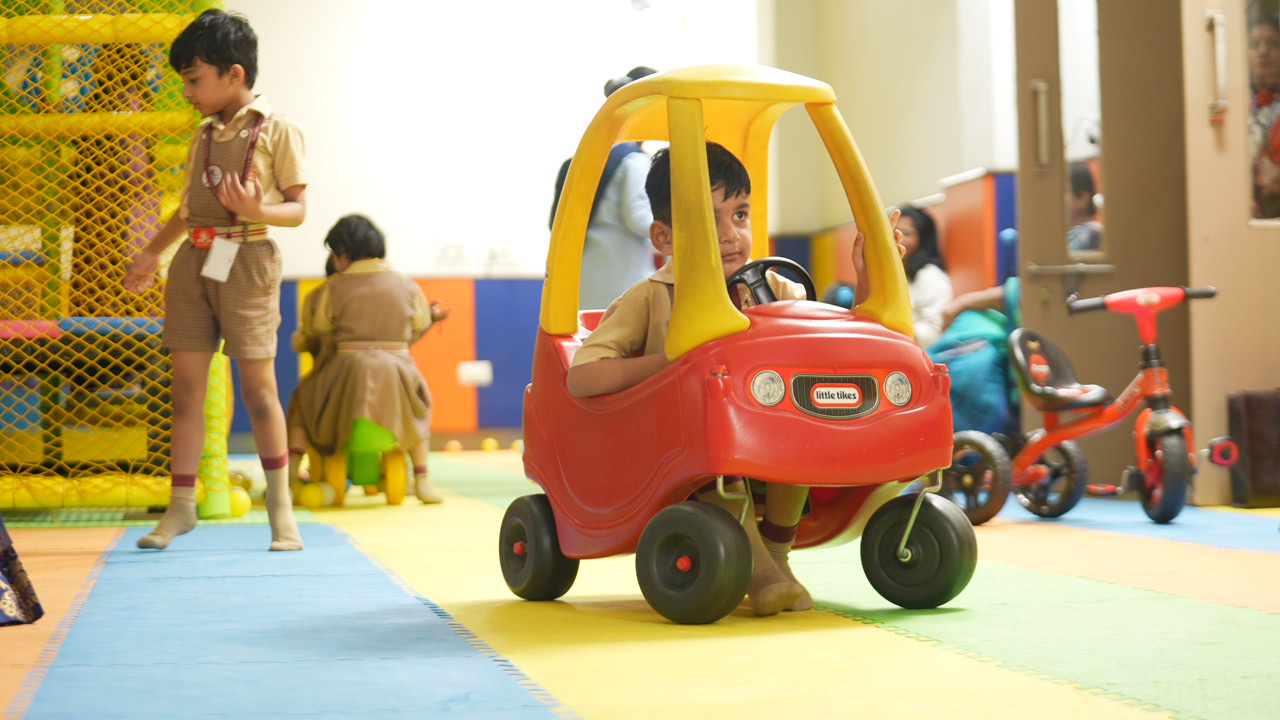 SKS World School children riding toy cars and playing in the indoor play zone